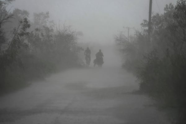 FILE - People travel in the rain after the passage of Hurricane Rafael in Guanimar, Cuba, Nov. 7, 2024. (AP Photo/Ramon Espinosa, File)