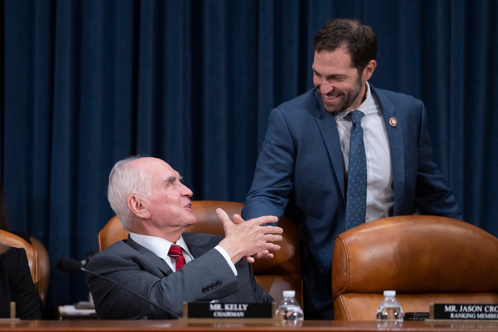 Chairman Rep. Mike Kelly, R-Pa., left, greets Ranking Member Rep. Jason Crow, D-Colo., right, at the first public hearing of a bipartisan congressional task force investigating the assassination attempts against Republican presidential nominee former President Donald Trump, at Capitol Hill in Washington, Thursday, Sept. 26, 2024. (AP Photo/Ben Curtis)