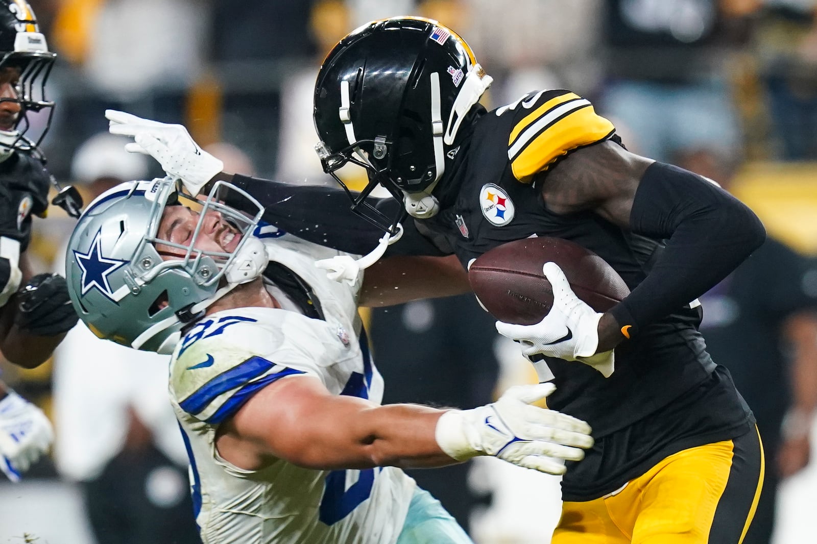 Pittsburgh Steelers cornerback Joey Porter Jr., right, puts a stiff arm on Dallas Cowboys tight end Jake Ferguson after making an interception during the second half of an NFL football game, early Monday, Oct. 7, 2024, in Pittsburgh. The Cowboys won 20-17. (AP Photo/Matt Freed)