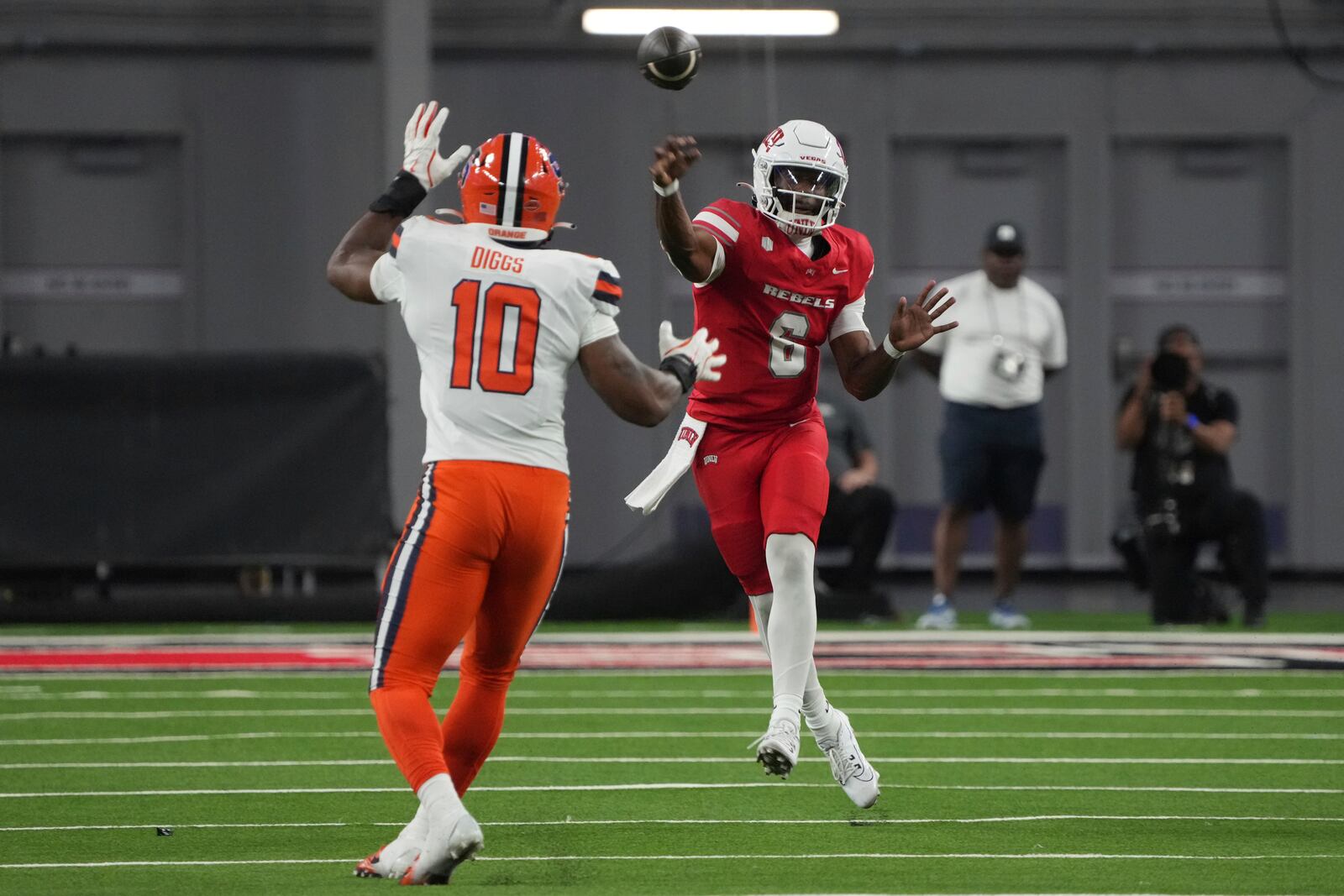 UNLV quarterback Hajj-Malik Williams, right, throws over Syracuse defensive lineman Fadil Diggs (10) in the first half during an NCAA college football game, Friday, Oct. 4, 2024, in Las Vegas. (AP Photo/Rick Scuteri)