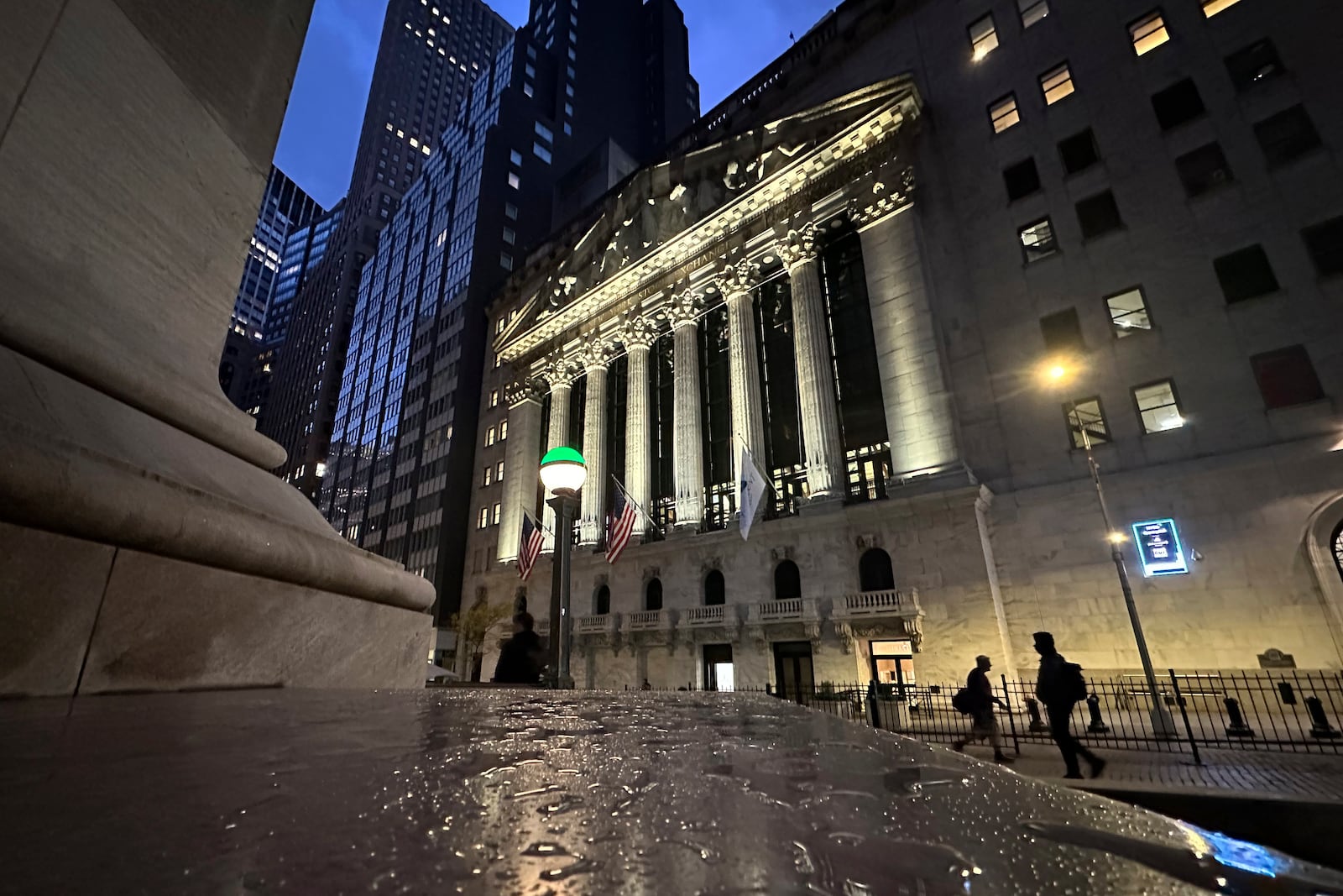 People pass the New York Stock Exchange early Tuesday, Oct. 29, 2024. (AP Photo/Peter Morgan)