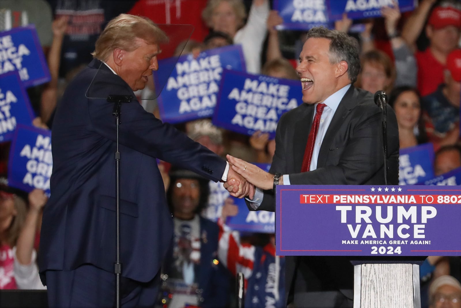 Republican presidential nominee former President Donald Trump shakes hands with Pennsylvania Senate candidate Dave McCormick at a campaign rally at Bayfront Convention Center in Erie, Pa., Sunday, Sept. 29, 2024. (AP Photo/Rebecca Droke)