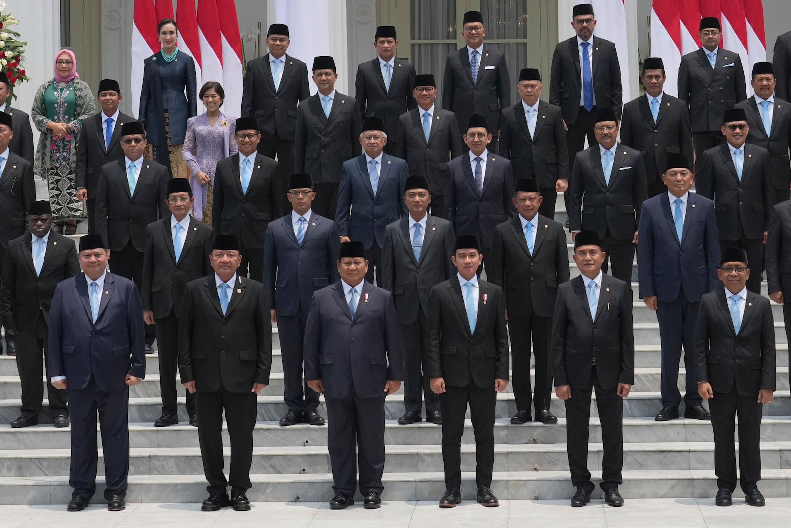 Front row, from left, Indonesia's Coordinating Minister for Economics Airlangga Hartarto, Coordinating Minister for Political and Security Affairs Budi Gunawan, President Prabowo Subianto, Vice President Gibran Rakabuming Raka, Coordinating Minister for Legal, Human Rights, Immigration and Correctional Affairs Yusril Ihza Mahendra, and Coordinating Minister for Human Development and Cultural Affairs Pratikno pose for a group photo with newly-appointed ministers during the swearing-in ceremony of the new cabinet at Merdeka Palace in Jakarta, Indonesia, Monday, Oct. 21, 2024. (AP Photo/Achmad Ibrahim)