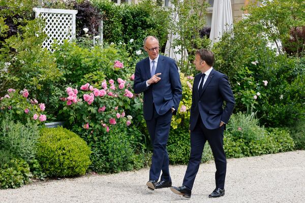 German Chancellor Friedrich Merz, left, speaks with French President Emmanuel Macron in the garden of the Elysee palace in Paris, Wednesday, May 7, 2025.(Ludovic Marin, Pool via AP)