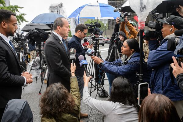 Israeli Minister of Economy and Industry Nir Barkat, center, talks with journalists at the scene as law enforcement work the area after two staff members of the Israeli Embassy in Washington were shot and killed outside the Capital Jewish Museum, Thursday, May 22, 2025, in Washington. (AP Photo/Rod Lamkey, Jr.)