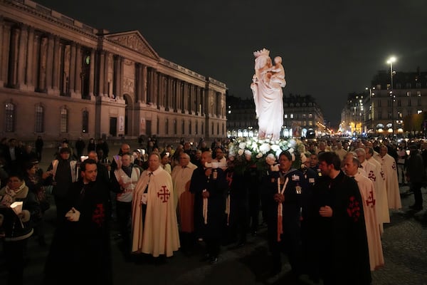 A replica of the Virgin Mary statue is carried from Saint-Germain l'Auxerrois church to Notre-Dame cathedral during a procession, Friday, Nov. 15, 2024 in Paris. (AP Photo/Christophe Ena)