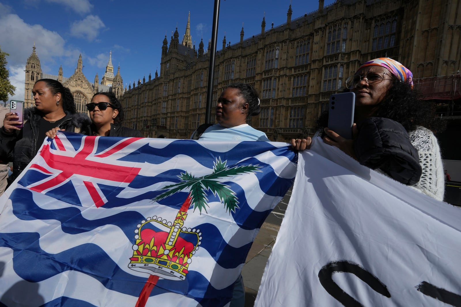 Mary Marjorie Sophie, center, and other Chagossians attend a protest to respond to the U.K. announcement agreeing to hand sovereignty of the long-contested Chagos Islands to Mauritius and against their "Exclusion" from Chagos negotiations, outside the House of Parliament, in London, Monday, Oct. 7, 2024. (AP Photo/Kin Cheung)