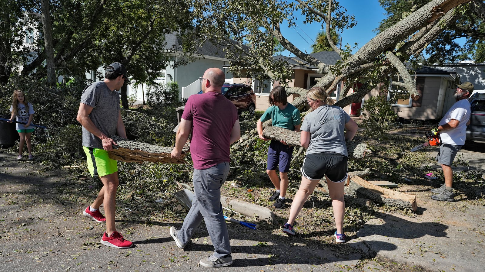 Neighbors help take down a tree felled by winds from Hurricane Milton, Sunday, Oct. 13, 2024, in Tampa, Fla. (AP Photo/Chris O'Meara)