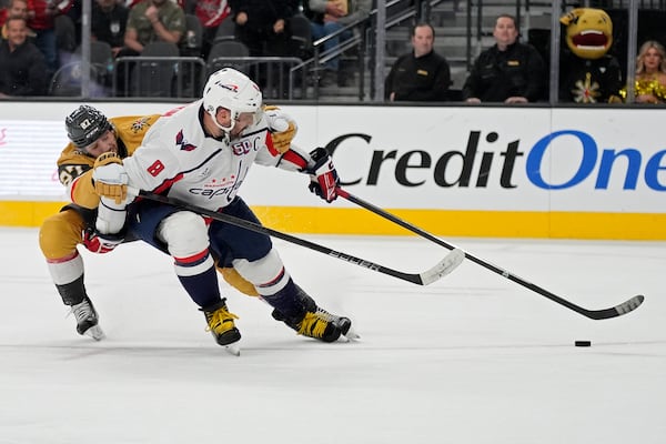 Washington Capitals left wing Alex Ovechkin (8) scores an open net goal past Vegas Golden Knights defenseman Shea Theodore (27) for a hat trick during the third period of an NHL hockey game Sunday, Nov. 17, 2024, in Las Vegas. (AP Photo/John Locher)