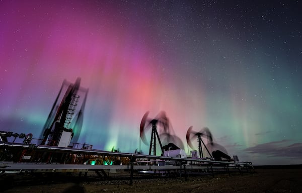 FILE - An aurora borealis, also known as the northern lights, makes an appearance over pumpjacks as they draw out oil and gas from well heads near Cremona, Alberta, Thursday, Oct. 10, 2024. (Jeff McIntosh/The Canadian Press via AP, File)