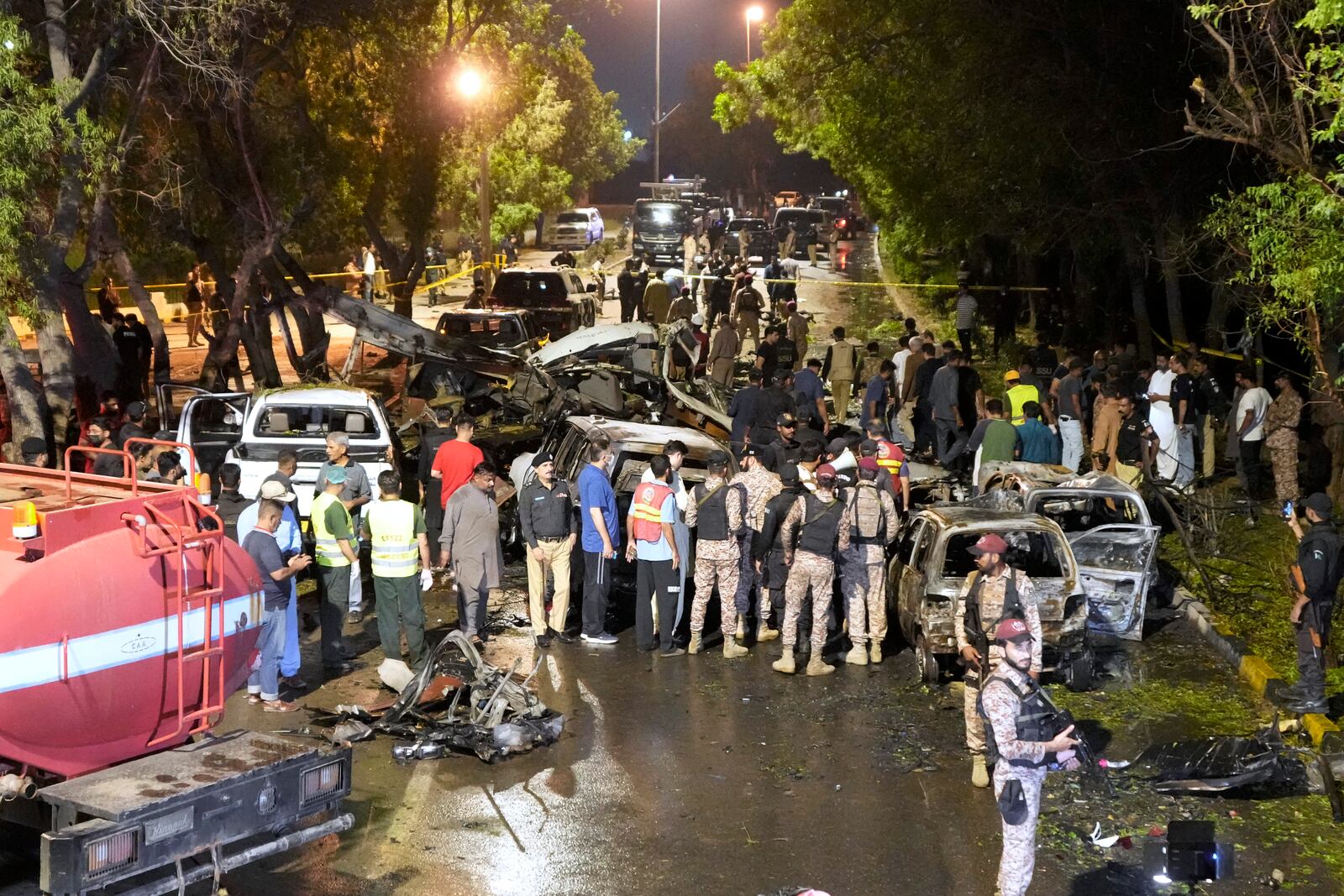 Security officials examine the site of an explosion that caused injures and destroyed vehicles at outside the Karachi airport, Pakistan, Monday, Oct. 7, 2024. (AP Photo/Fareed Khan)