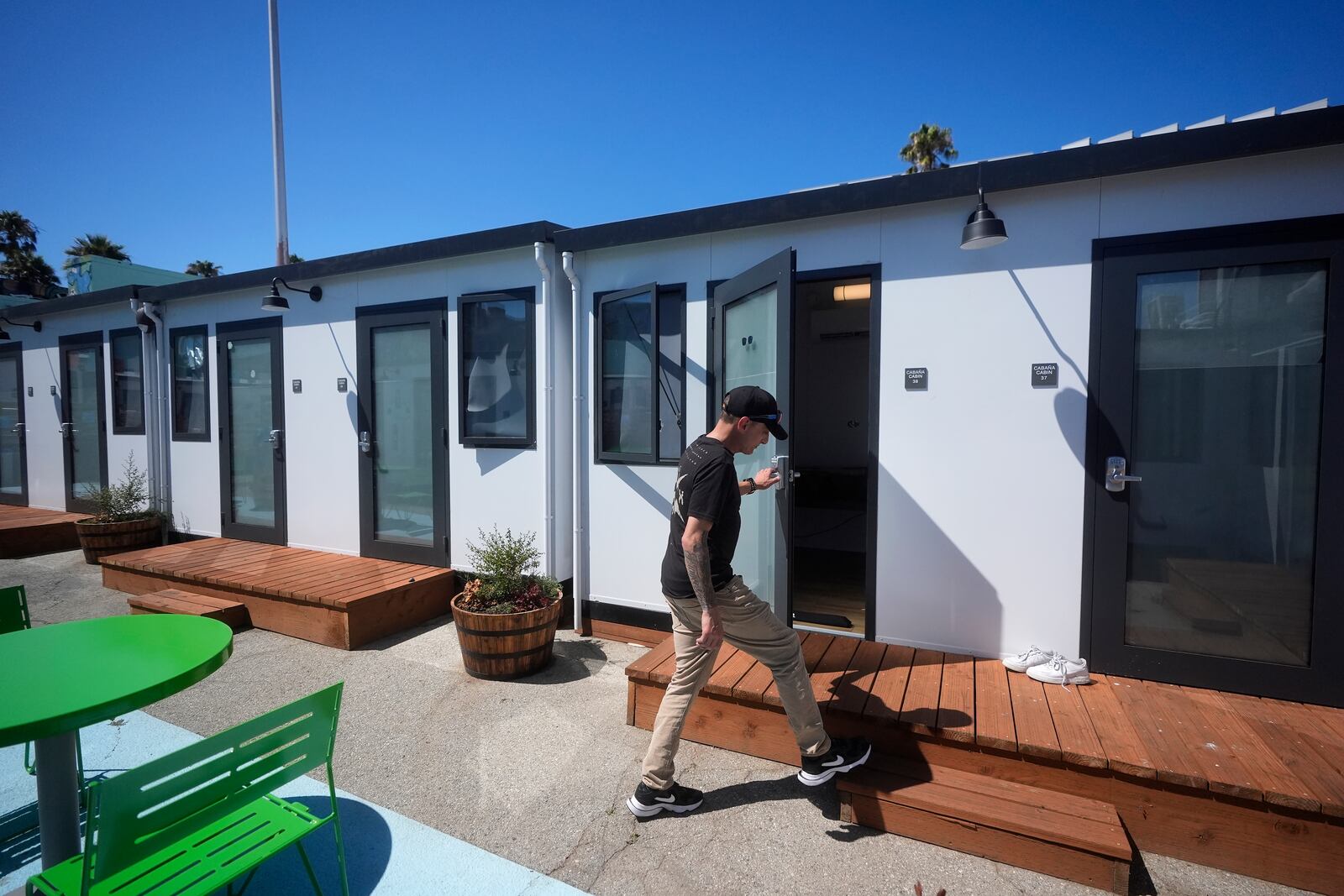 Steven Burcell walks to his room at the Five Keys' Mission Cabins transitional housing location in San Francisco, Monday, Aug. 26, 2024. (AP Photo/Jeff Chiu)