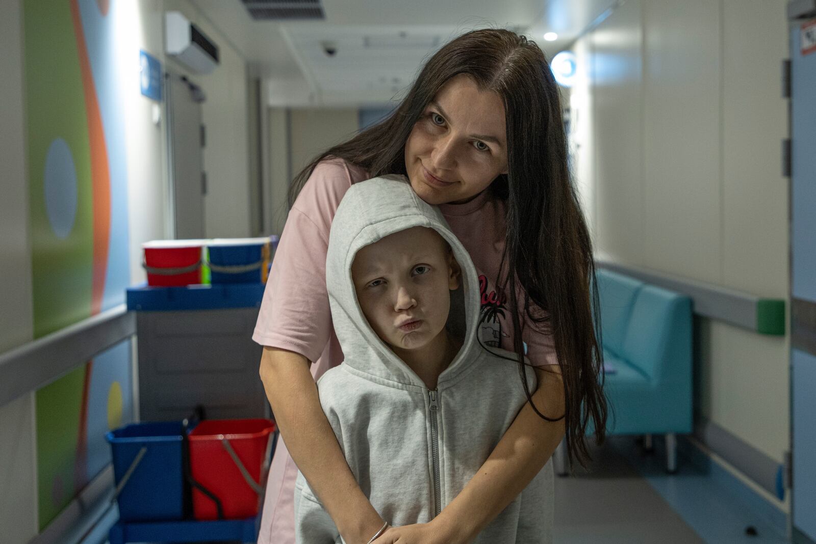 Kira Vertetska, 8 and her mother Daria pose for a photo in a corridor at Okhmatdyt children's hospital in Kyiv, Ukraine, Thursday Sept. 19, 2024. (AP Photo/Anton Shtuka)