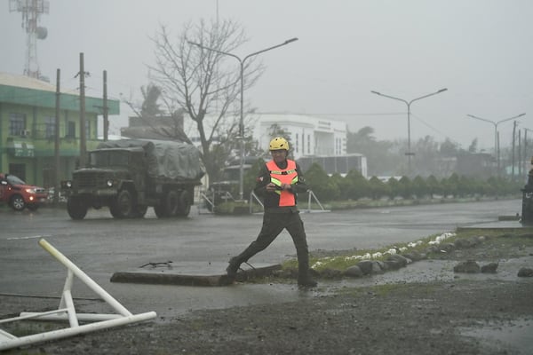 An army rescuer crosses the streets during heavy rains caused by Typhoon Usagi at Santa Ana, Cagayan province, northern Philippines on Thursday, Nov. 14, 2024. (AP Photo/Noel Celis)