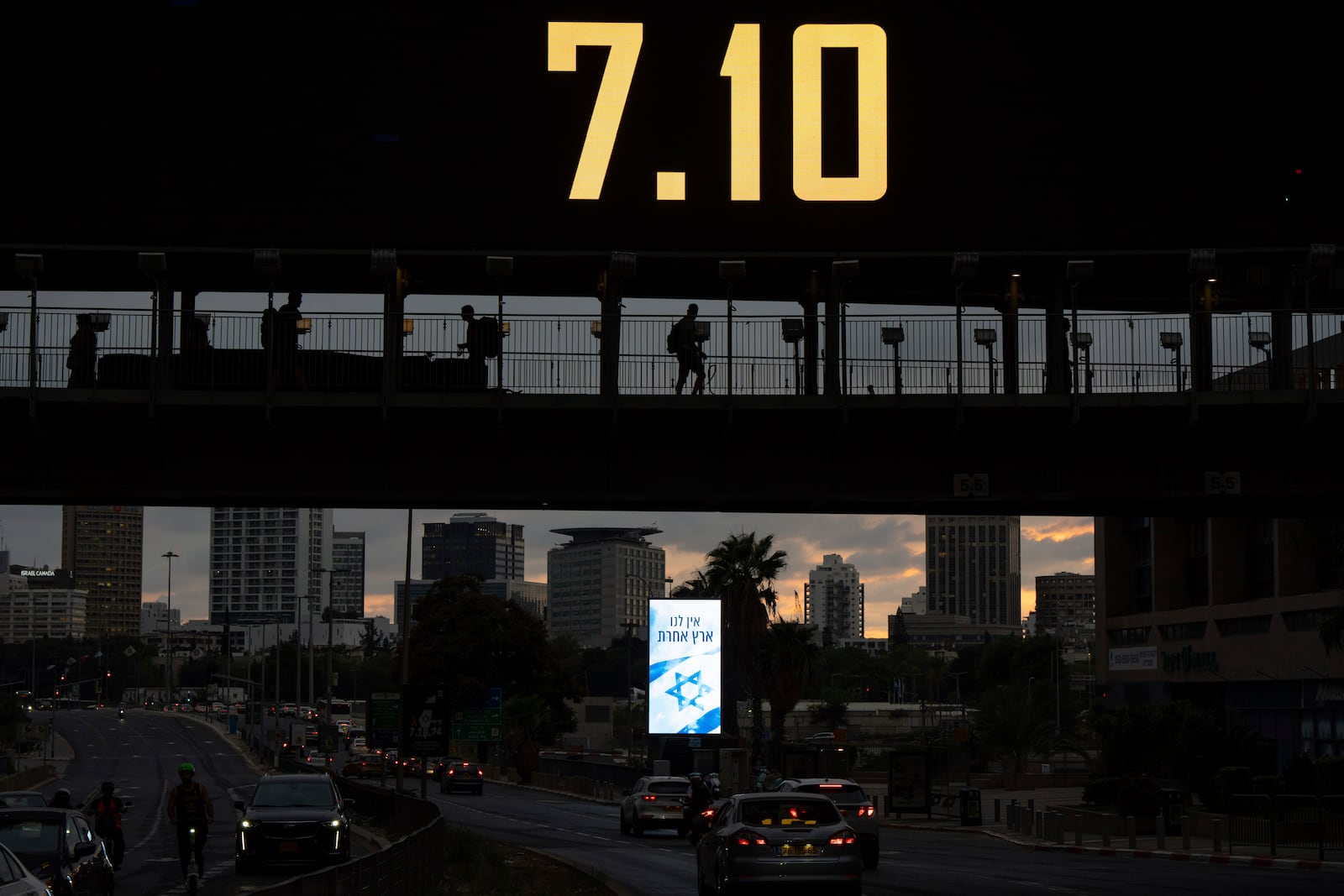 People cross a bridge with the date 7.10, marking the one-year anniversary of the Hamas attack on Israel, in Ramat Gan, Israel, Sunday, Oct. 6, 2024. (AP Photo/Oded Balilty)