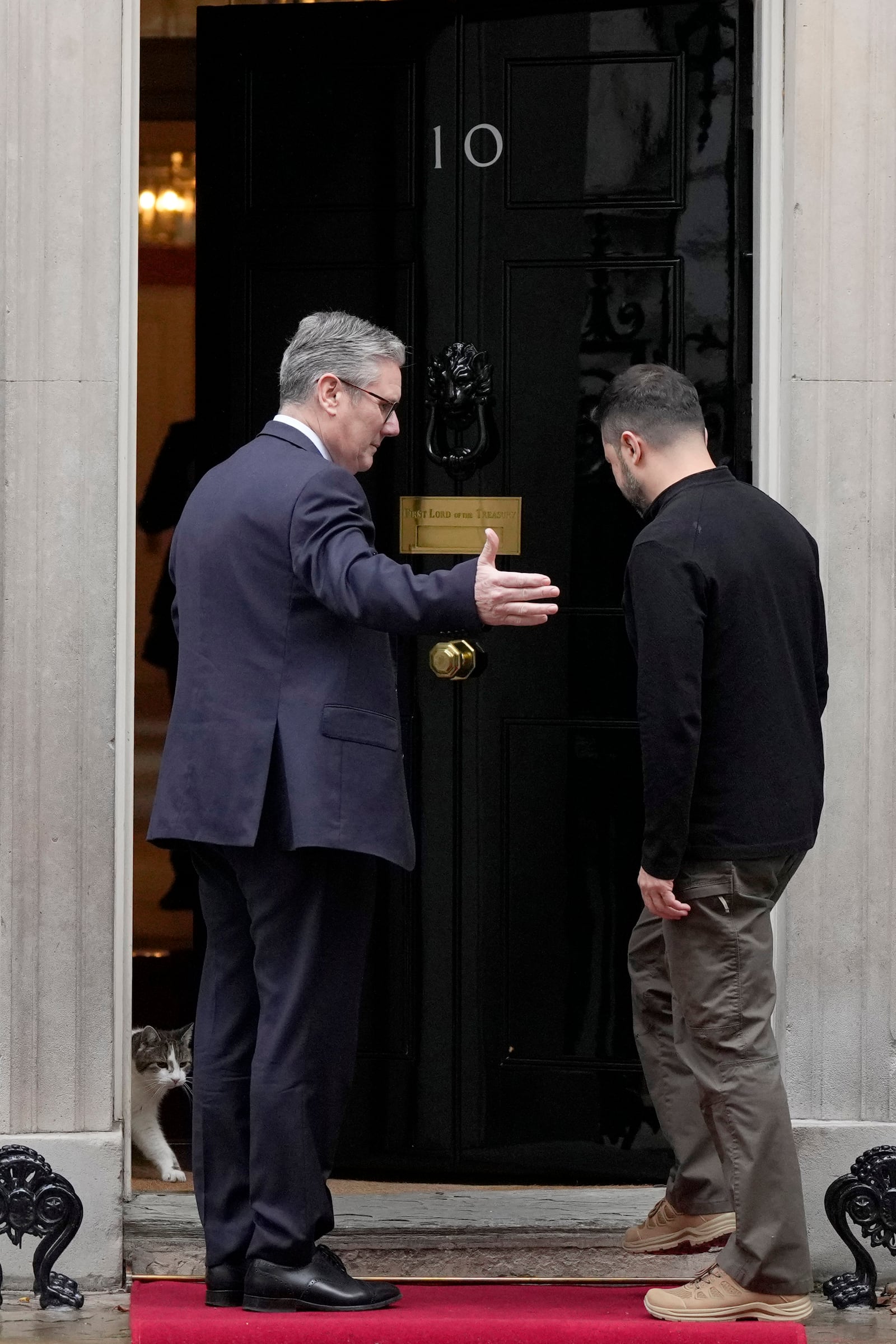 Britain's Prime Minister Keir Starmer welcomes Ukrainian President Volodymyr Zelenskyy to 10 Downing Street as Larry the cat, Chief Mouser to the Cabinet Office, steps out in London, Thursday, Oct. 10, 2024.(AP Photo/Alastair Grant)