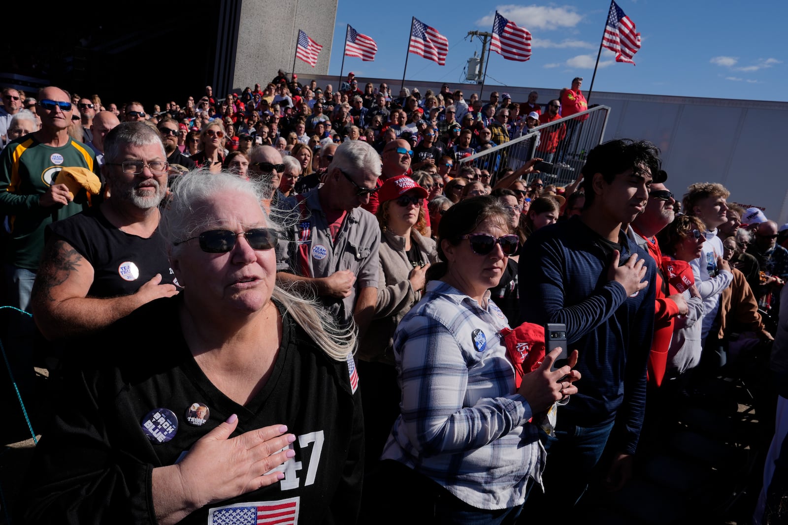 Attendees say the Pledge of Allegiance at a campaign rally for Republican presidential nominee former President Donald Trump at Dodge County Airport, Sunday, Oct. 6, 2024, in Juneau, Wis. (AP Photo/Julia Demaree Nikhinson)