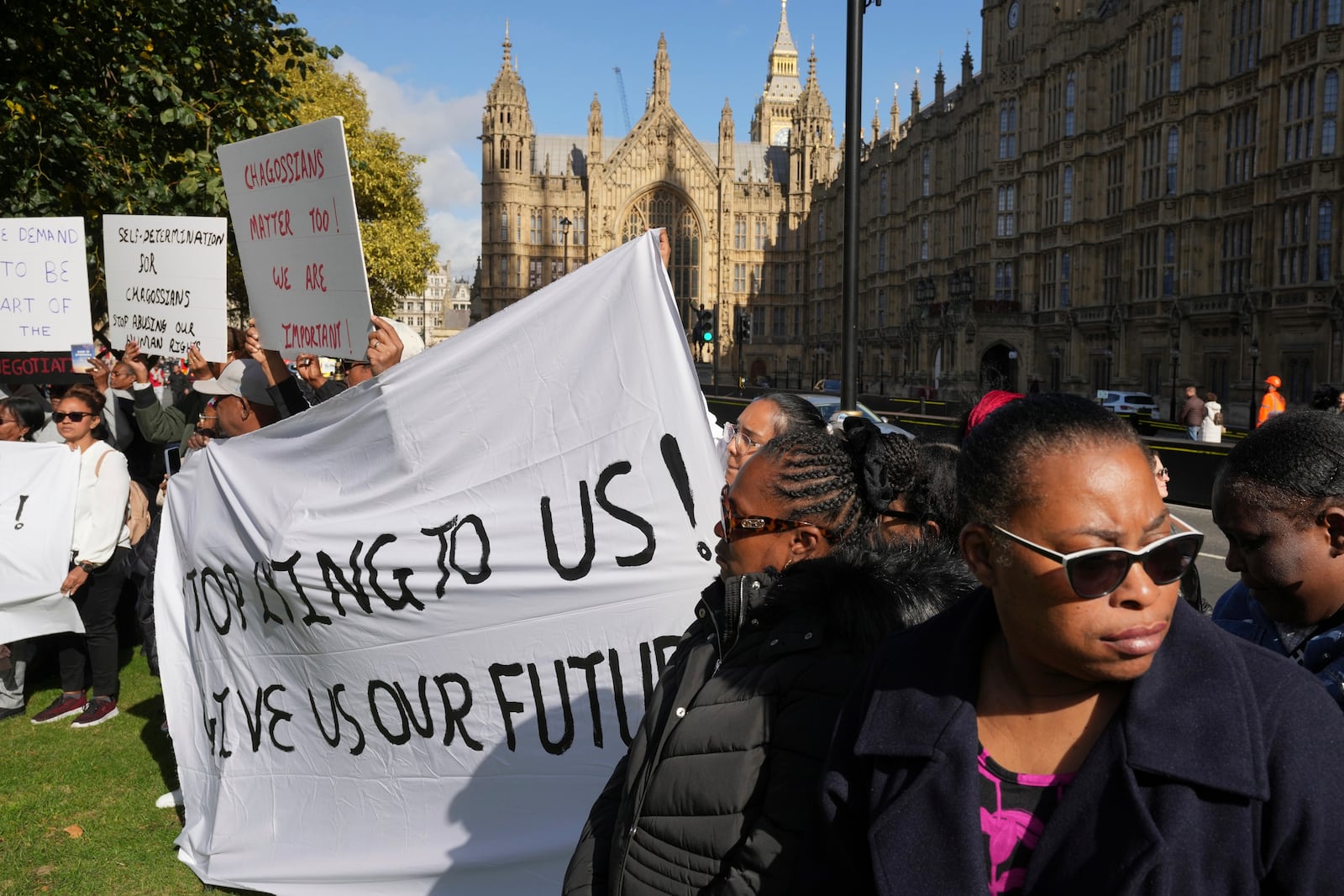 Chagossians attend a protest to response the U.K. announcement to agree to hand sovereignty of the long-contested Chagos Islands to Mauritius and against their "Exclusion" from Chagos negotiations, outside the House of Parliament, in London, Monday, Oct. 7, 2024. (AP Photo/Kin Cheung)