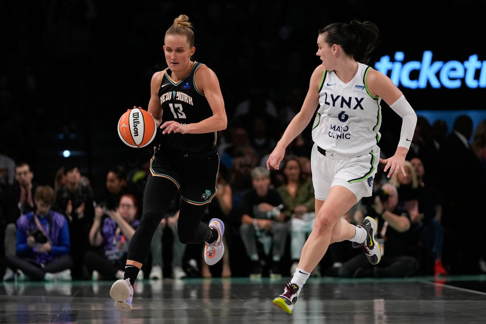 New York Liberty forward Leonie Fiebich (13) drives up the court against Minnesota Lynx forward Bridget Carleton (6) during the first quarter of Game 5 of the WNBA basketball final series, Sunday, Oct. 20, 2024, in New York. (AP Photo/Pamela Smith)