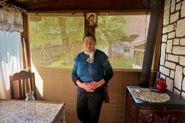 Liliana Cosurean, 54, stands in her home, in the village of Floresti, in Romania's central Transylvania region, Thursday, April 24, 2025. (AP Photo/Stephen McGrath)
