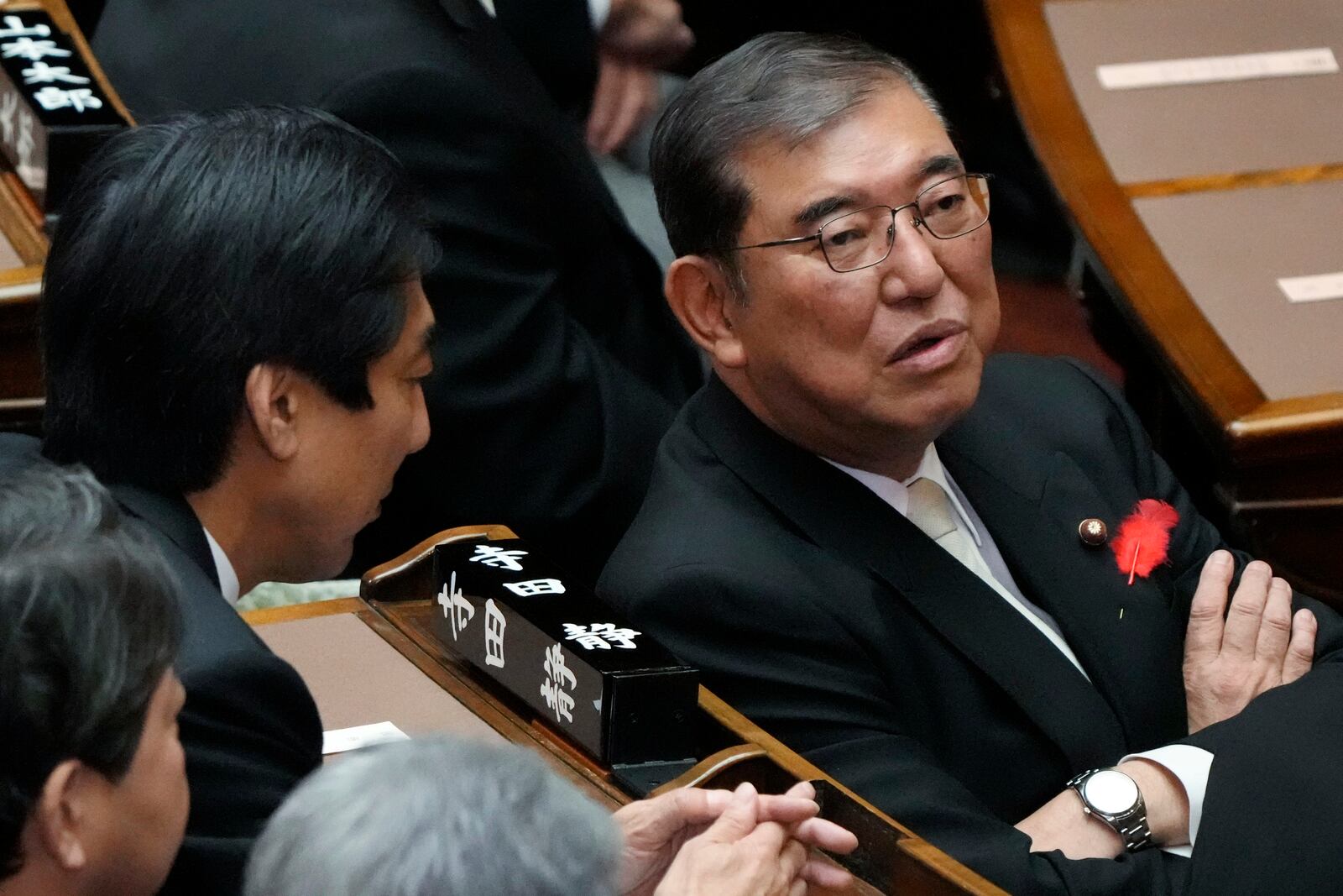 Japanese Prime Minister Shigeru Ishiba, right, speaks with other lawmakers prior to a Diet session at the Upper House of the Parliament Friday, Oct. 4, 2024, in Tokyo. (AP Photo/Eugene Hoshiko)