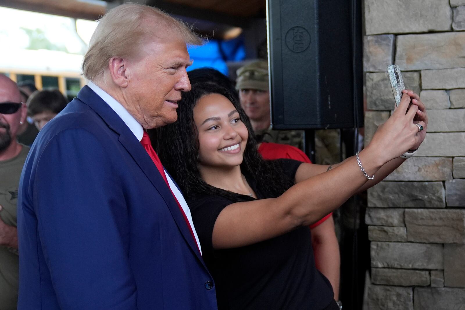 Republican presidential nominee former President Donald Trump greets people at a temporary relief shelter as he visits areas impacted by Hurricane Helene, Friday, Oct. 4, 2024, in Evans, Ga. (AP Photo/Evan Vucci)