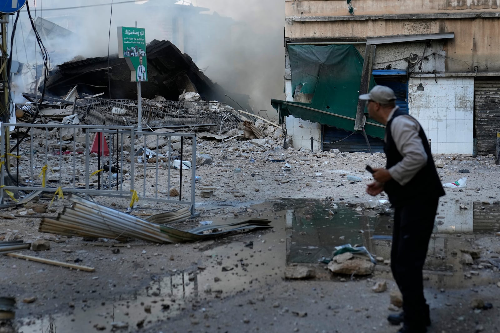 A man checks a destroyed building where he was living and which was hit by Israeli airstrike in Dahiyeh, Beirut, Lebanon, Sunday, Oct. 6, 2024. (AP Photo/Hussein Malla)