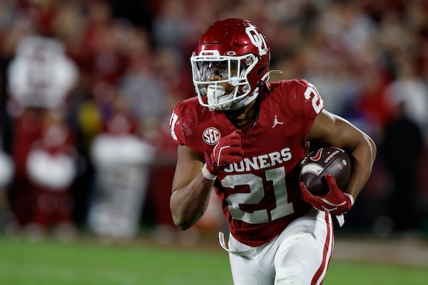 Oklahoma running back Xavier Robinson (21) runs for a first down against Alabama during the second half of a NCAA college football game Saturday, Nov. 23, 2024, in Norman, Okla. (AP Photo/Alonzo Adams)