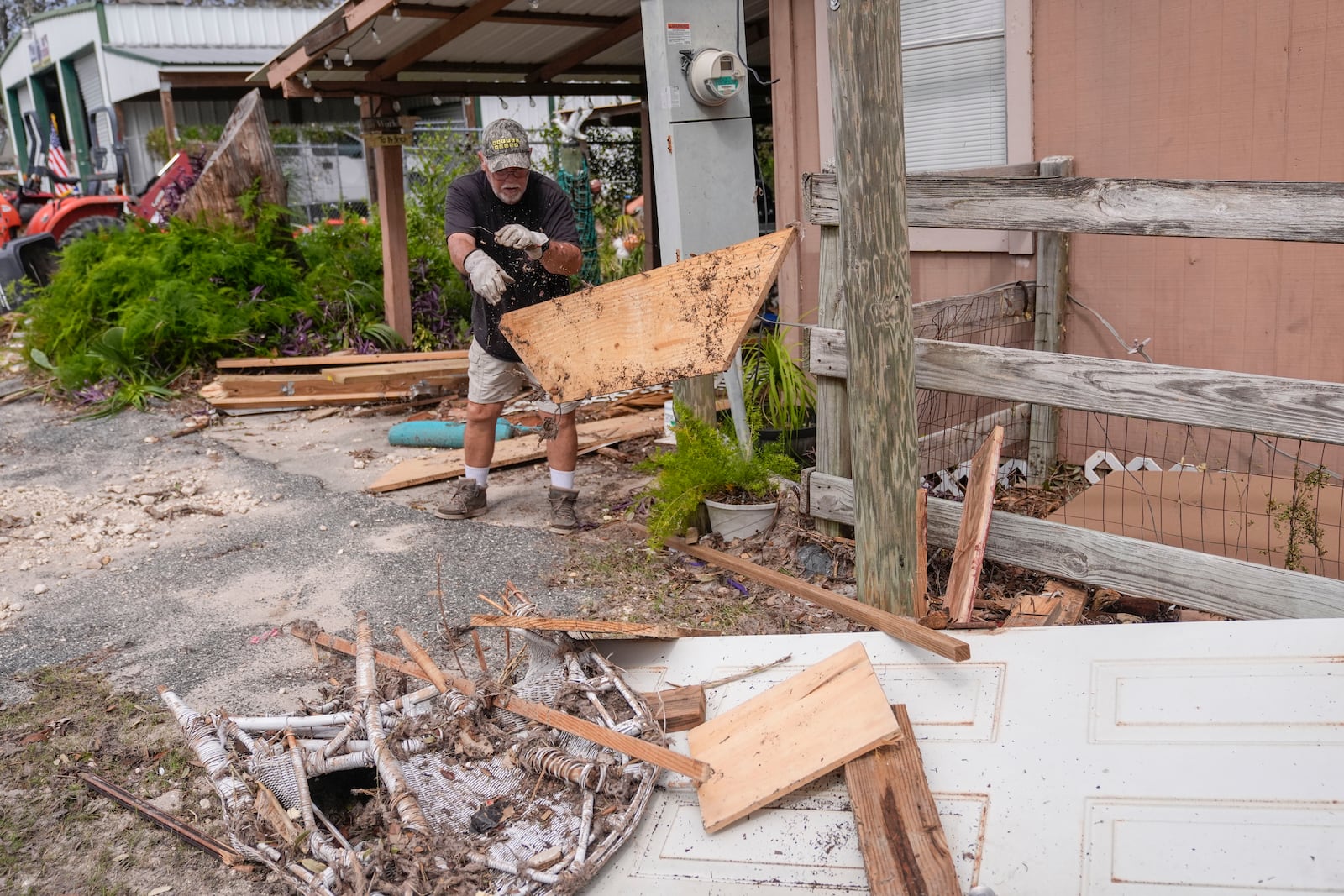 Dennis Johnson cleans out debris from his mother-in-law's heavily damaged home in the aftermath of Hurricane Helene, in Horseshoe Beach, Fla., Saturday, Sept. 28, 2024. (AP Photo/Gerald Herbert)