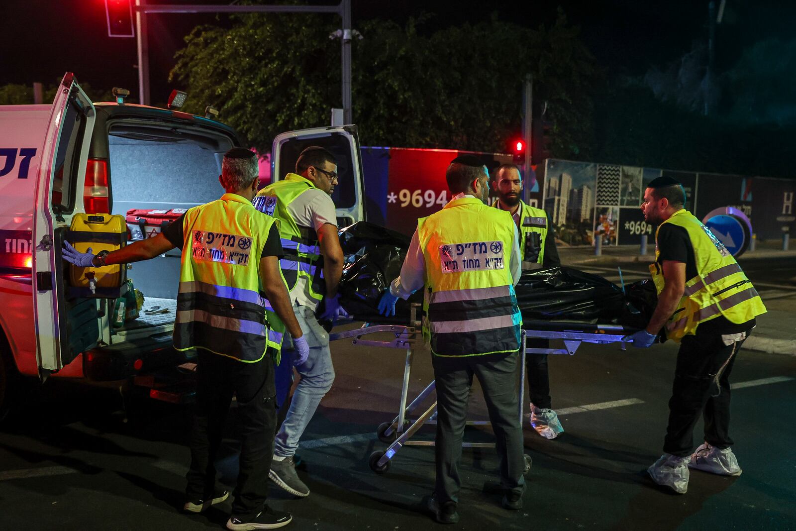 Members of Zaka Rescue and Recovery team load a dead person into an ambulance following a shooting attack in Jaffa, a mixed Arab-Jewish area of Tel Aviv, Israel, Tuesday, Oct. 1, 2024. (AP Photo/Itai Ron)