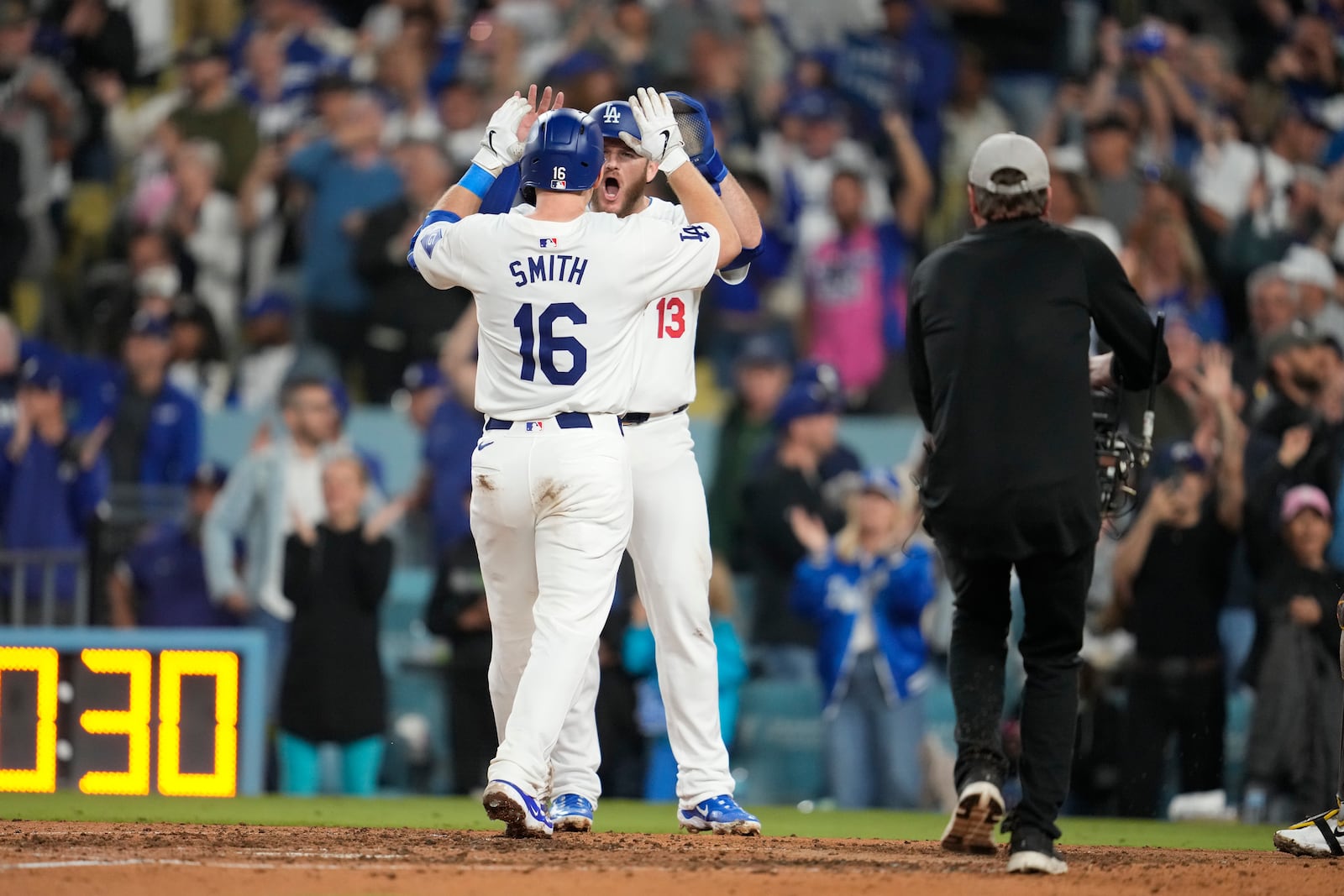 Los Angeles Dodgers' Will Smith (16) celebrates with teammate Max Muncy after hitting a two-run home run during the seventh inning of a baseball game against the San Diego Padres, Thursday, Sept. 26, 2024, in Los Angeles. (AP Photo/Ashley Landis)