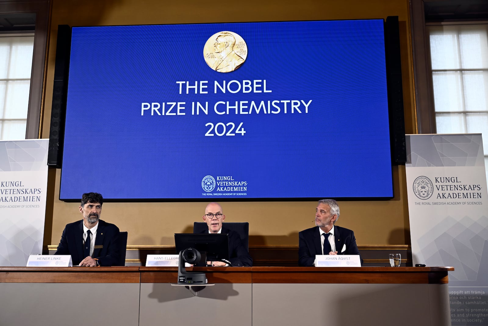 Johan Åqvist, member of the Nobel Committee for Chemistry, Hans Ellegren, Permanent Secretary and Heiner Linke, Chairman of the Nobel Committee for Chemistry award this years Nobel Prize in Chemistry to David Baker, Demis Hassabis, and John Jumper at the Royal Swedish Academy of Sciences, in Stockholm, Sweden, Wednesday, Oct. 9, 2024. (Christine Olsson/TT News Agency via AP)