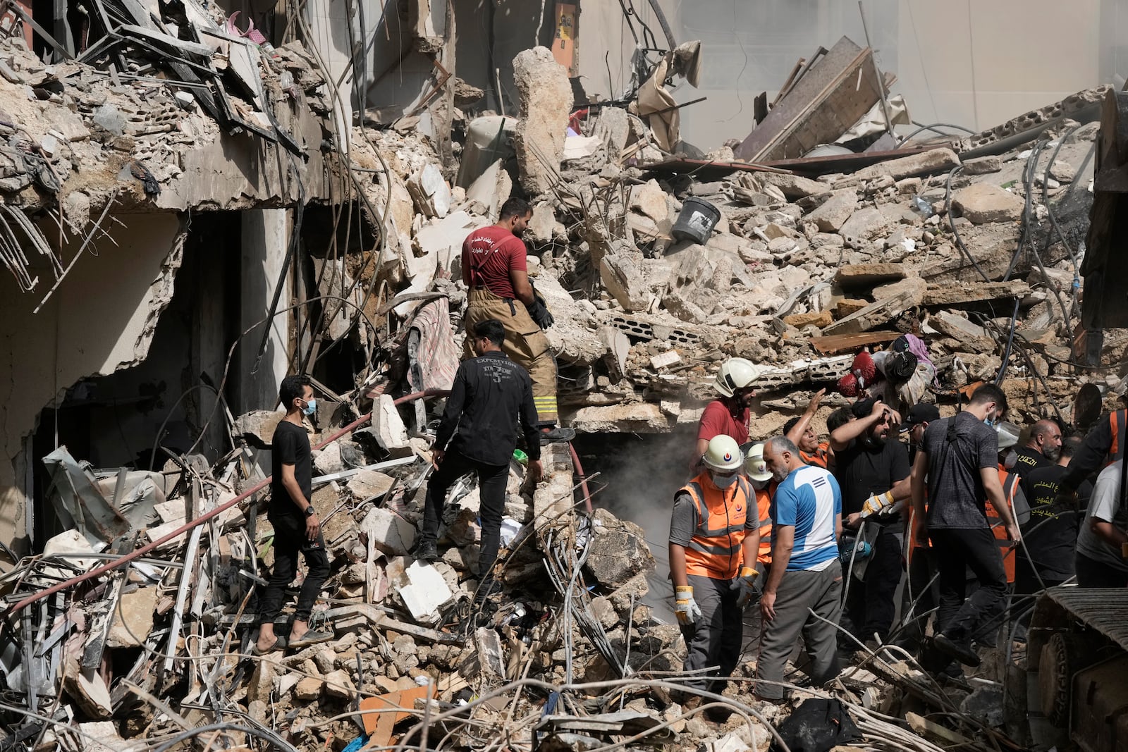 Emergency workers clear the rubble at the site of Friday's Israeli strike in Beirut's southern suburbs, Saturday, Sept. 21, 2024. (AP Photo/Bilal Hussein)