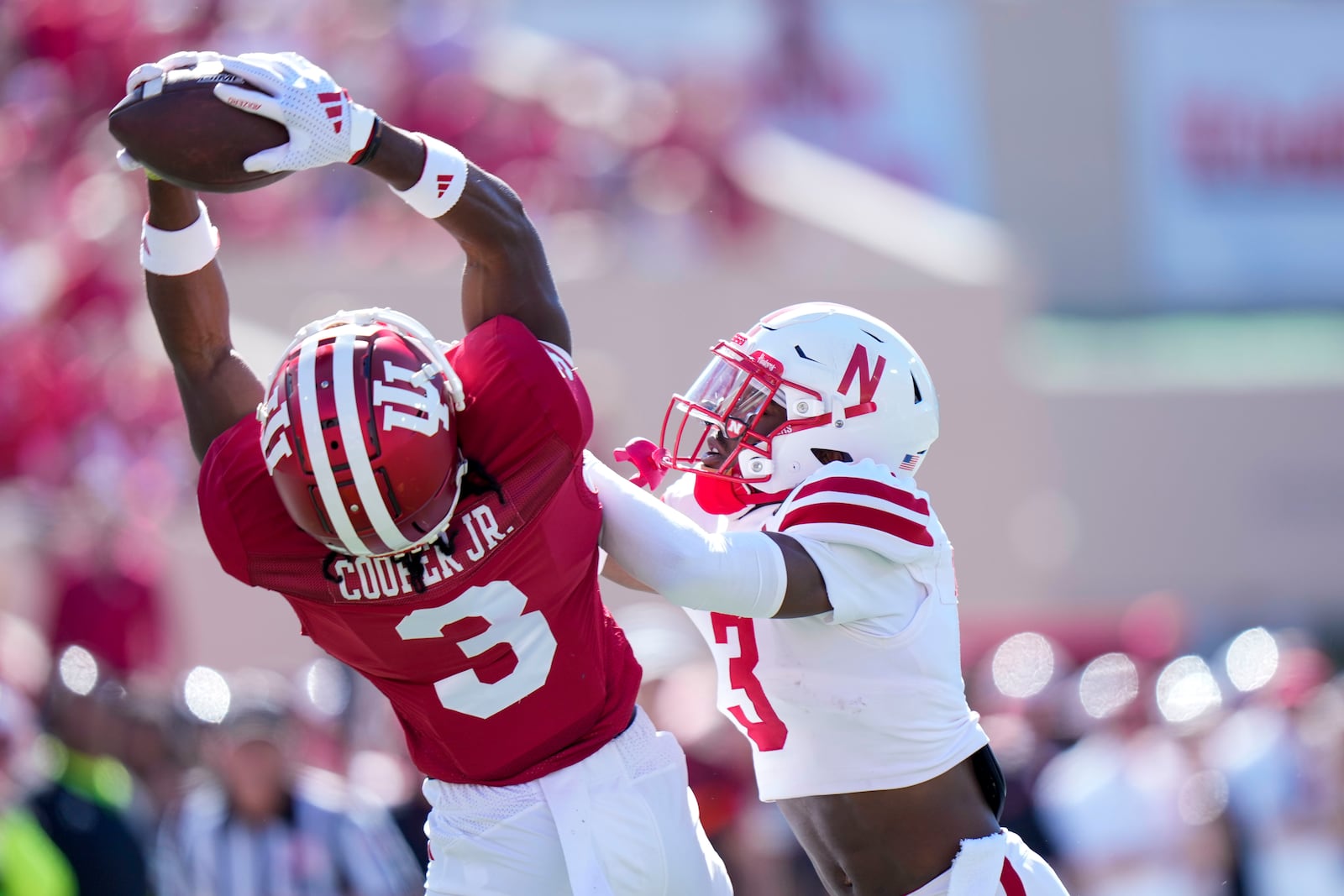 Indiana wide receiver Omar Cooper Jr., left, pulls in a pass under the defense of Nebraska defensive back Marques Buford Jr. (3) during the first half of an NCAA college football game in Bloomington, Ind., Saturday, Oct. 19, 2024. (AP Photo/AJ Mast)