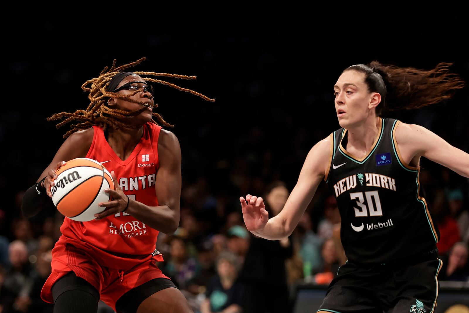 Atlanta Dream guard Rhyne Howard drives past New York Liberty forward Breanna Stewart (30) during the second half of first-round WNBA basketball playoff game, Tuesday, Sept. 24, 2024, in New York. The Liberty won 91-82 to clinch the series 2-0. (AP Photo/Adam Hunger)