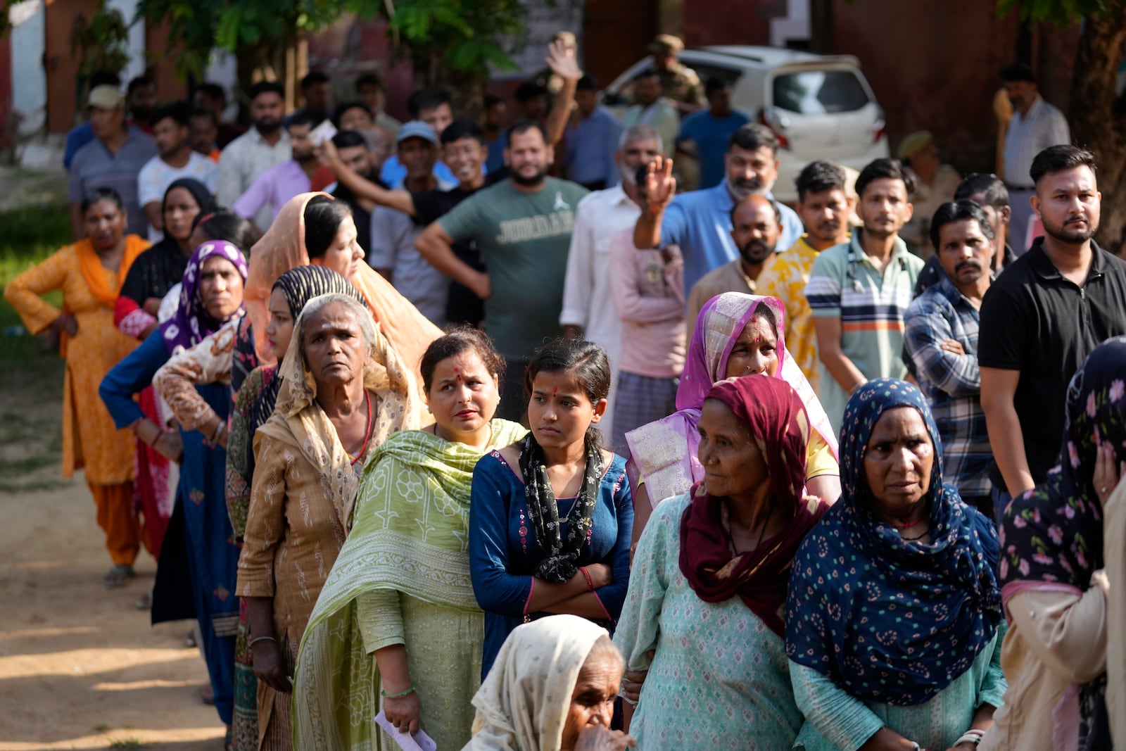 People queue up to cast their vote at a polling booth during the final phase of an election to choose a local government in Indian-controlled Kashmir, in Jammu, India, Tuesday, Oct.1, 2024. (AP Photos/Channi Anand)