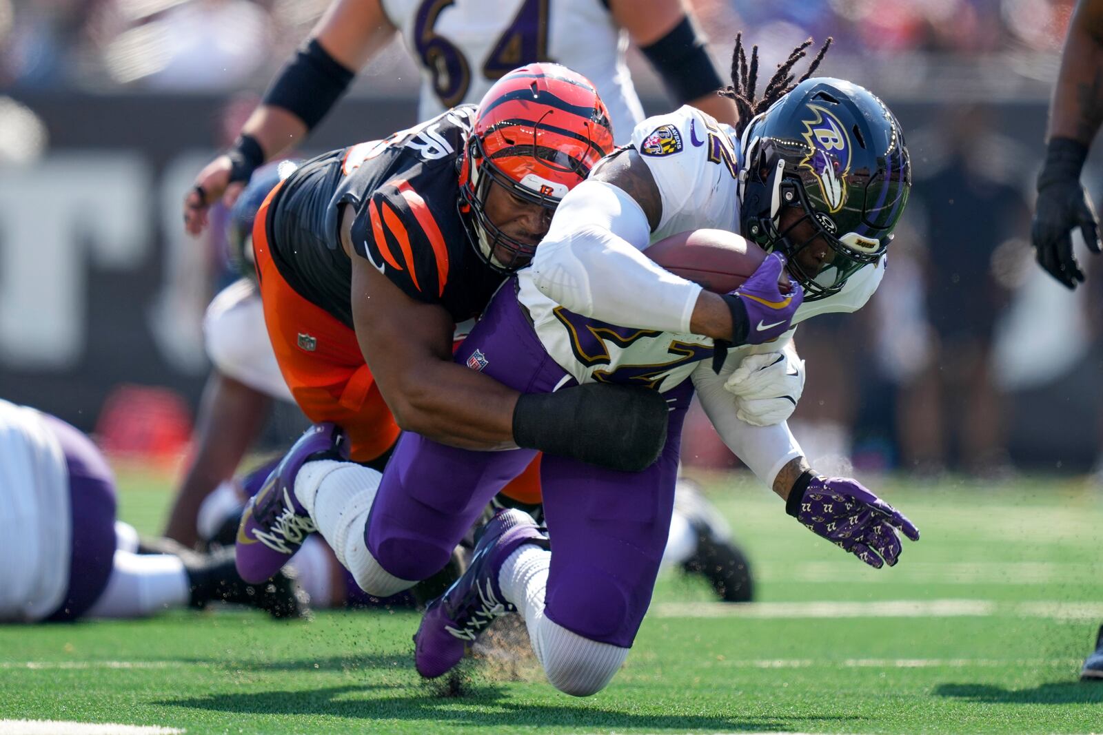 Baltimore Ravens running back Derrick Henry (22) takes a hit from a Cincinnati Bengals defensive tackle Kris Jenkins Jr. during the first half of an NFL football game, Sunday, Oct. 6, 2024, in Cincinnati. (AP Photo/Carolyn Kaster)