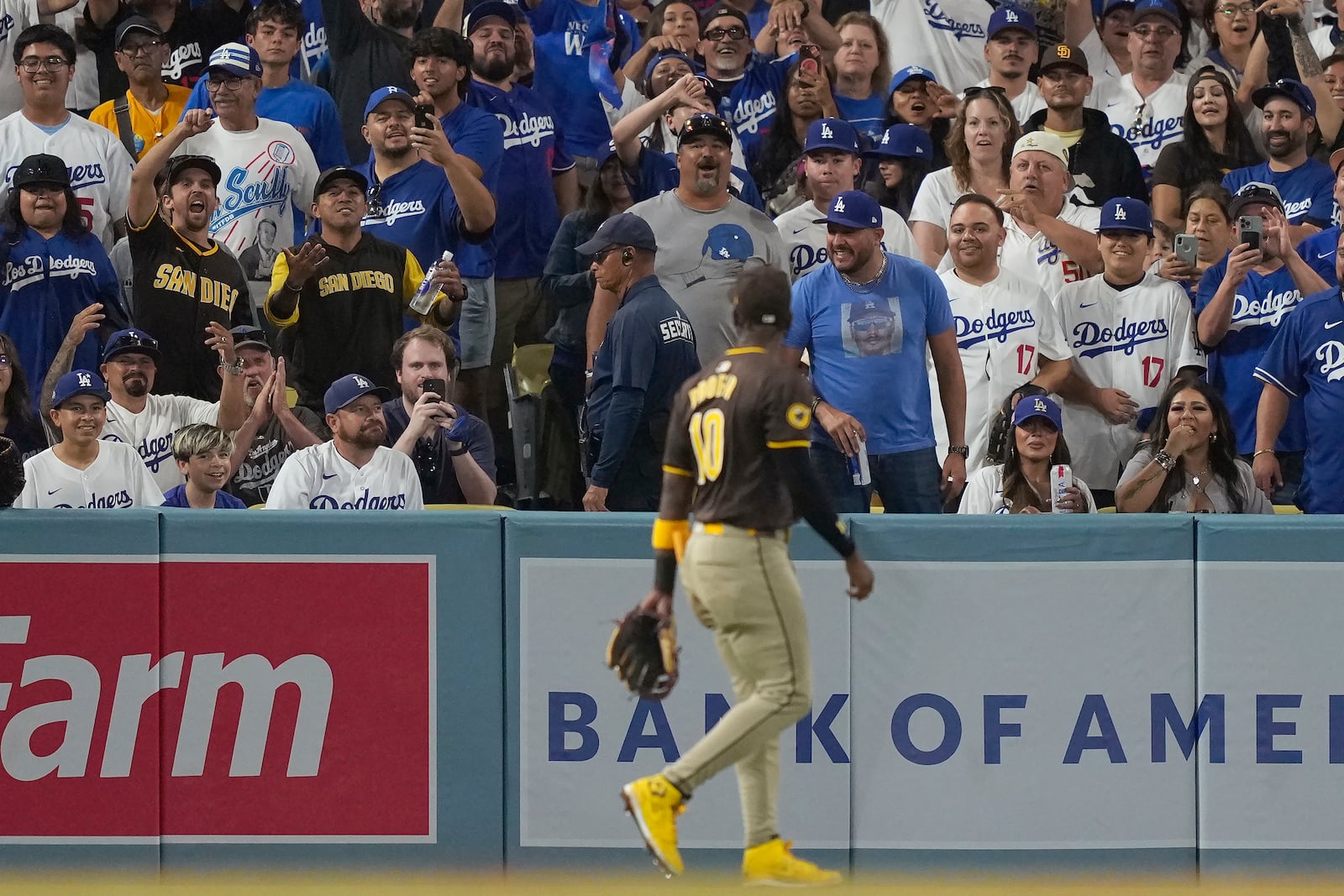 Fans react toward San Diego Padres left fielder Jurickson Profar, foreground, after items were thrown at him in the outfield during the seventh inning in Game 2 of a baseball NL Division Series between the Los Angeles Dodgers and the Padres, Sunday, Oct. 6, 2024, in Los Angeles. (AP Photo/Mark J. Terrill)