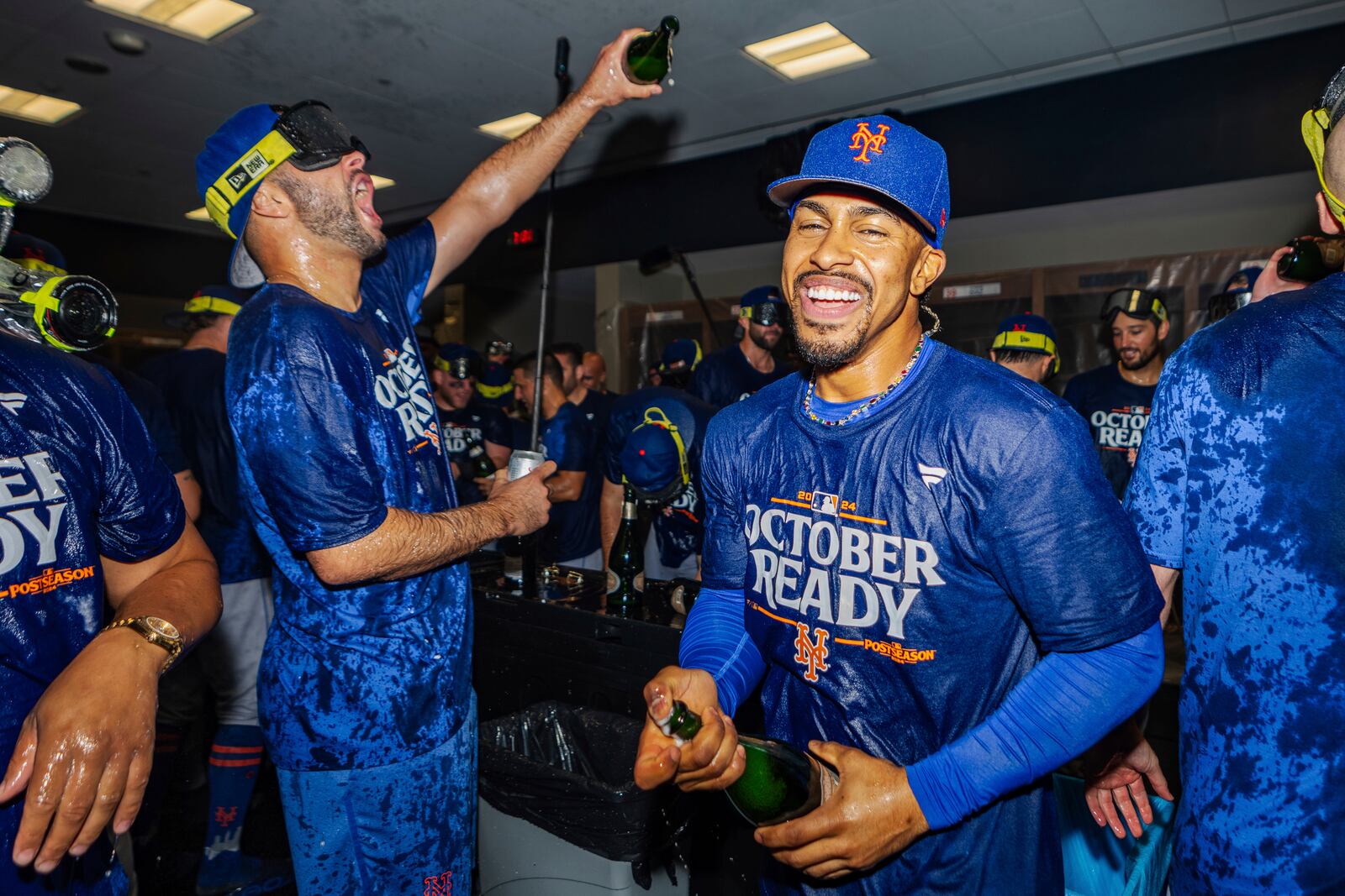 The New York Mets celebrate in the locker room after clinching a playoff berth with a victory in the first baseball game of a doubleheader against the Atlanta Braves, Monday, Sept. 30, 2024, in Atlanta. (AP Photo/Jason Allen)