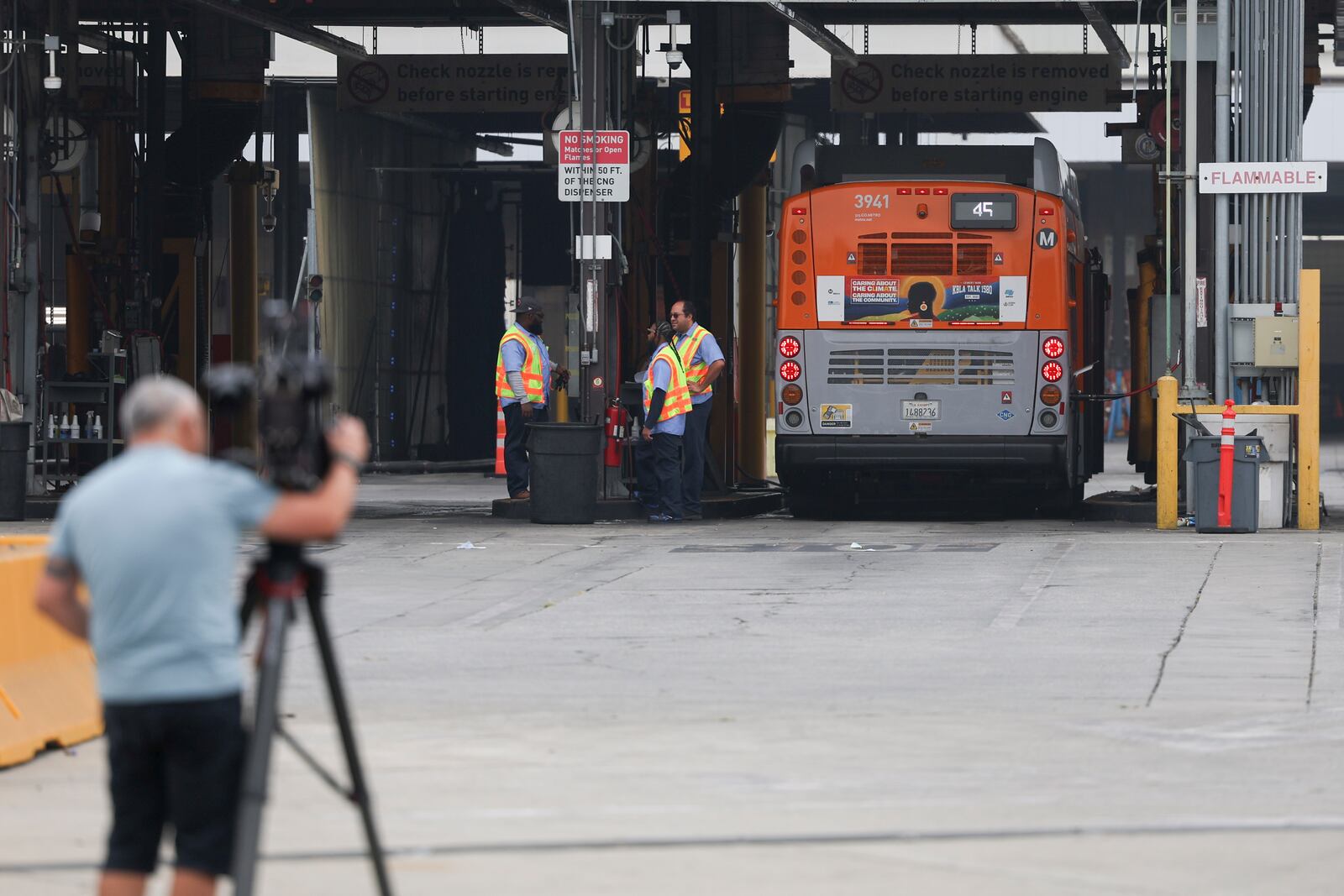 A news camera records in front of a Los Angeles MTA bus depot near the site where overnight a bus was hijacked by an armed subject with passengers on board Wednesday, Sept. 25, 2024, in Los Angeles. One person was fatally shot before police apprehended the suspect. (AP Photo/Ryan Sun)