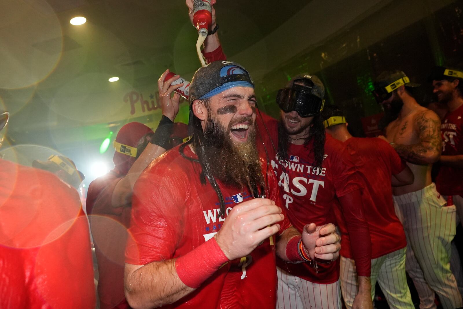 Philadelphia Phillies' Brandon Marsh, center left, and Matt Strahm celebrate after the Phillies won a baseball game against the Chicago Cubs to clinch the NL East title, Monday, Sept. 23, 2024, in Philadelphia. (AP Photo/Matt Slocum)