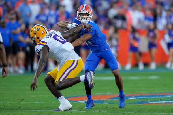 Florida wide receiver Aidan Mizell, right, dodges a tackle by LSU defensive end Paris Shand (0) during the first half of an NCAA college football game, Saturday, Nov. 16, 2024, in Gainesville, Fla. (AP Photo/John Raoux)