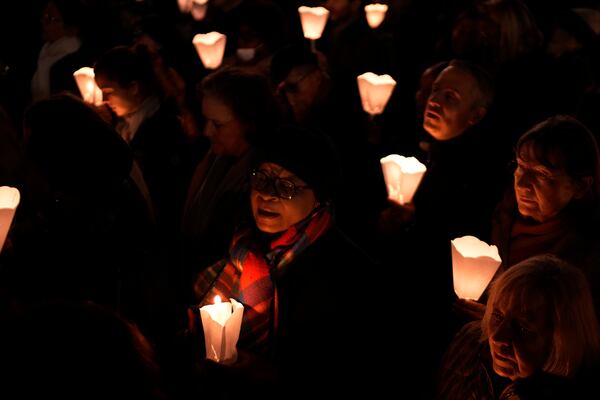 People hold candlelights during a blessing ceremony for the original Virgin Mary statue, which did not suffer from the 2019 fire, before its return in the Notre-Dame cathedral, Friday, Nov. 15, 2024 outside the cathedral in Paris. (AP Photo/Louise Delmotte)