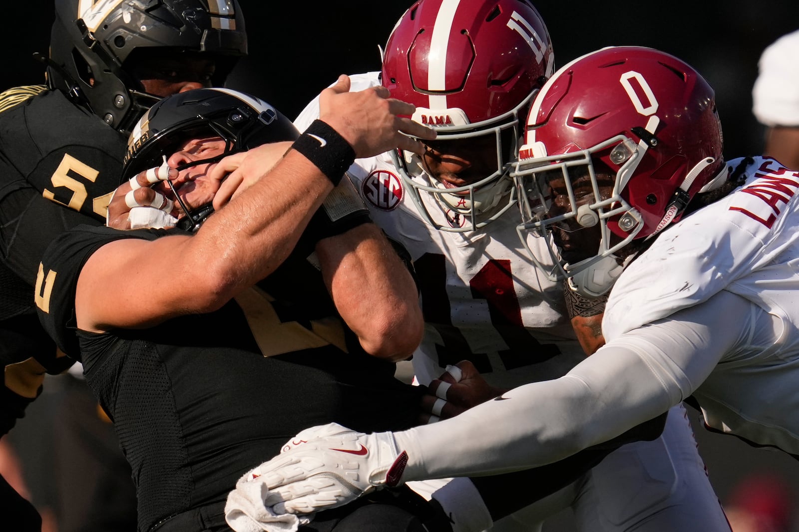 Vanderbilt quarterback Diego Pavia, left, is tackled by Alabama linebacker Jihaad Campbell (11) and linebacker Deontae Lawson (0) during the first half of an NCAA college football game Saturday, Oct. 5, 2024, in Nashville, Tenn. (AP Photo/George Walker IV)