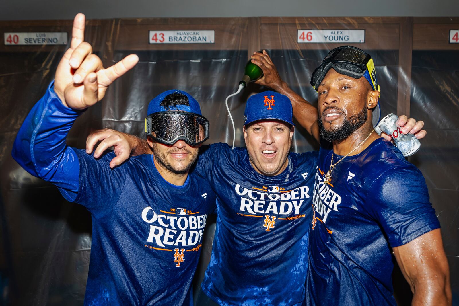 The New York Mets celebrate in the locker room after clinching a playoff berth with a victory in the first game of a doubleheader against the Atlanta Braves, Monday, Sept. 30, 2024, in Atlanta. (AP Photo/Jason Allen)