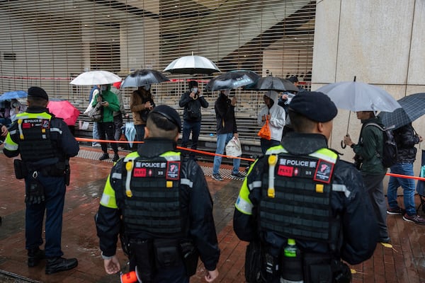 People wait to enter the West Kowloon Magistrates' Courts in Hong Kong, Wednesday, Nov. 20, 2024, ahead of Hong Kong activist publisher Jimmy Lai's national security trial. (AP Photo/Chan Long Hei)