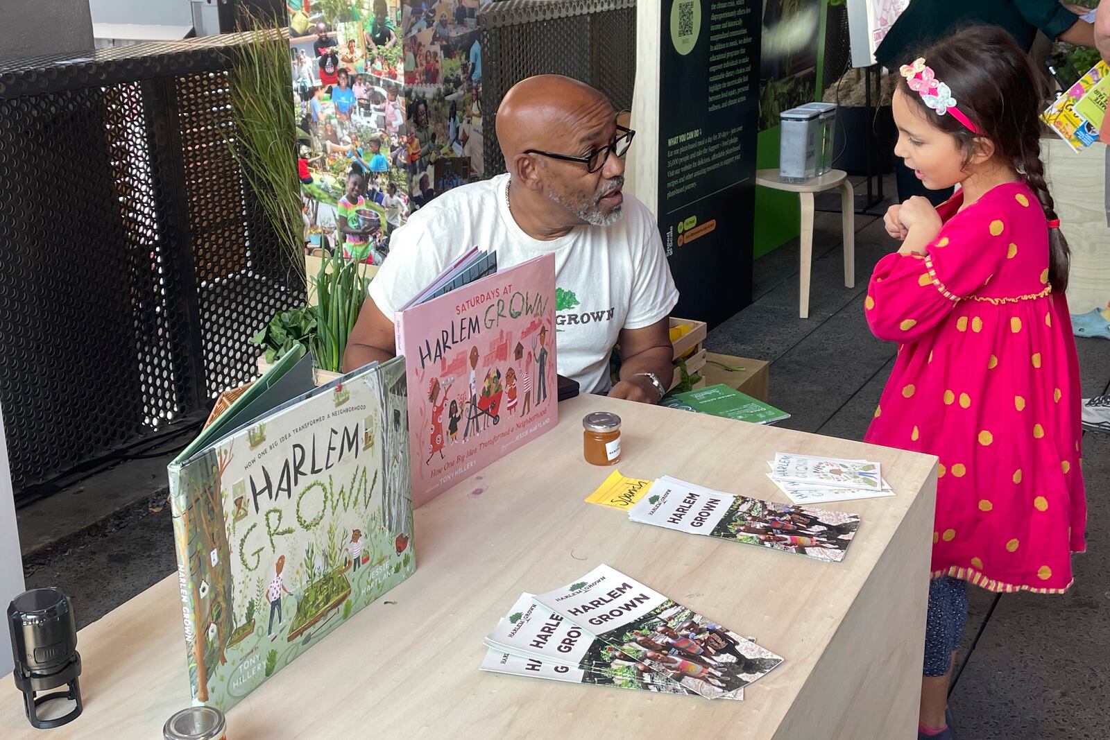 Tony Hillery, founder and CEO of Harlem Grown, a nonprofit that runs urban farms and works with children, speaks with a young fan at the Climate Science Fair on Sunday, Sept. 22, 2024 in New York. (AP Photo/Thalia Beaty)