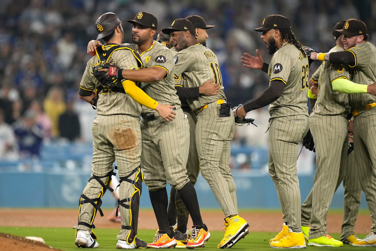 Members of the San Diego Padres celebrate after the Padres clinched a playoff spot with a triple play to end their baseball game as Los Angeles Dodgers' Shohei Ohtani stands at the plate, Tuesday, Sept. 24, 2024, in Los Angeles. (AP Photo/Mark J. Terrill)