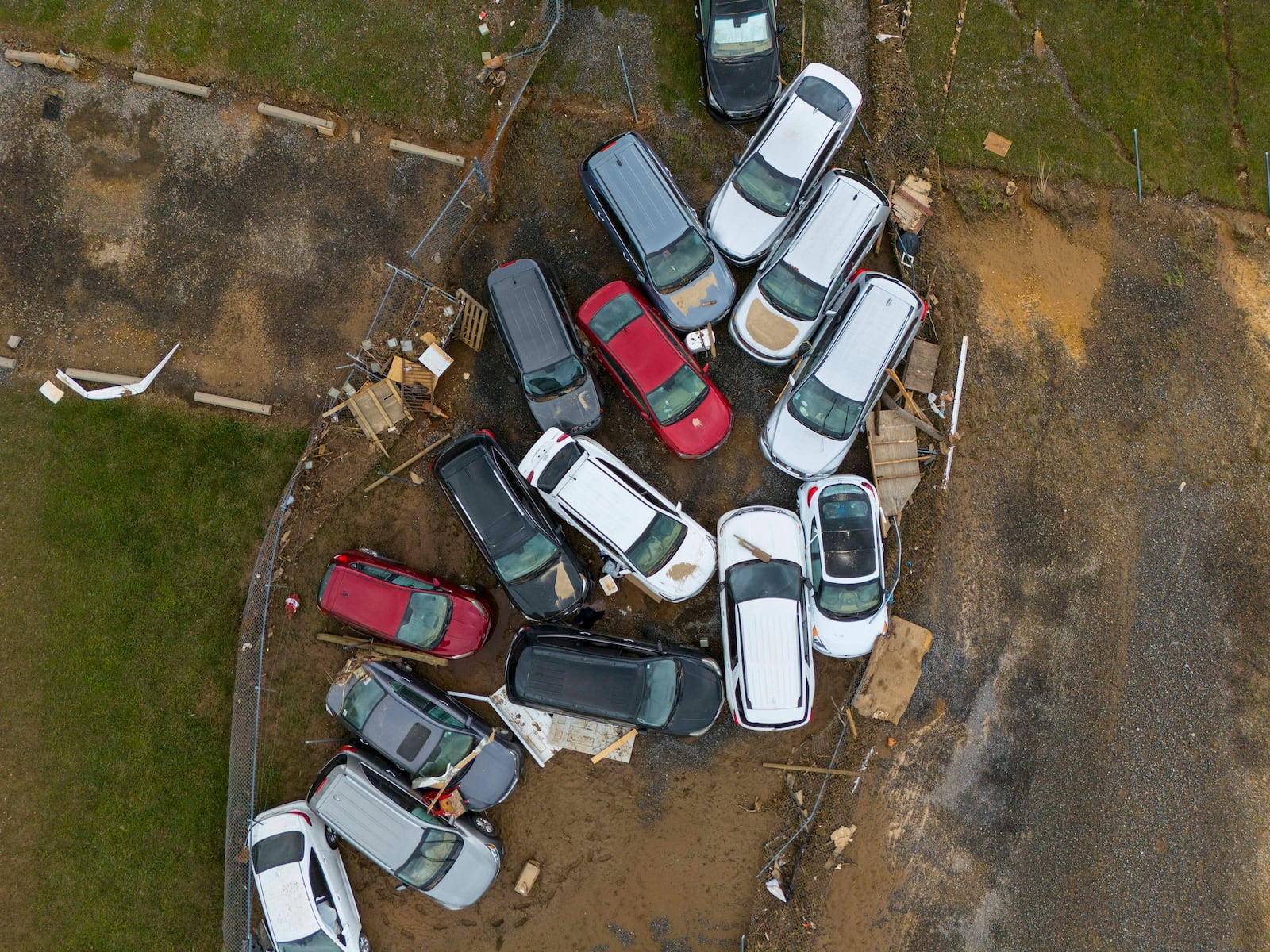 Vehicles and debris that were caught in a flash flood from Hurricane Helene rest on the side of the road near the Swannanoa River, Tuesday, Oct. 1, 2024, in Swannanoa, N.C. (AP Photo/Mike Stewart)