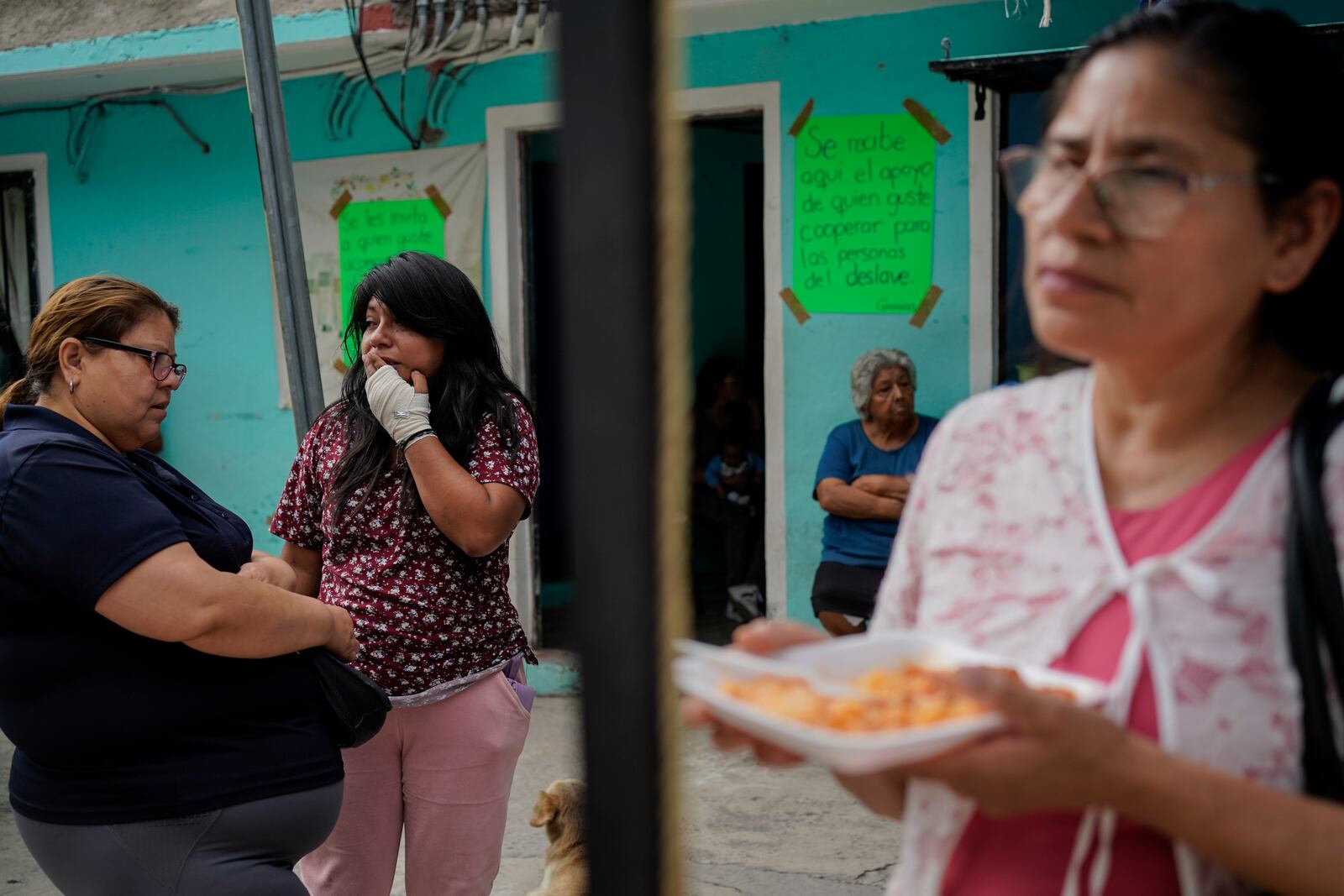 Estrella Bejarano, second from left, the mother of two children who died after a rain-induced landslide, speaks with relatives in Naucalpan, Mexico, Tuesday, Sept. 17, 2024. (AP Photo/Felix Marquez)